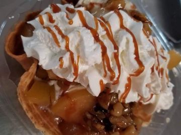 Homemade apple topping, fresh wet walnuts on vanilla ice cream.  Whipped cream and caramel drizzle.