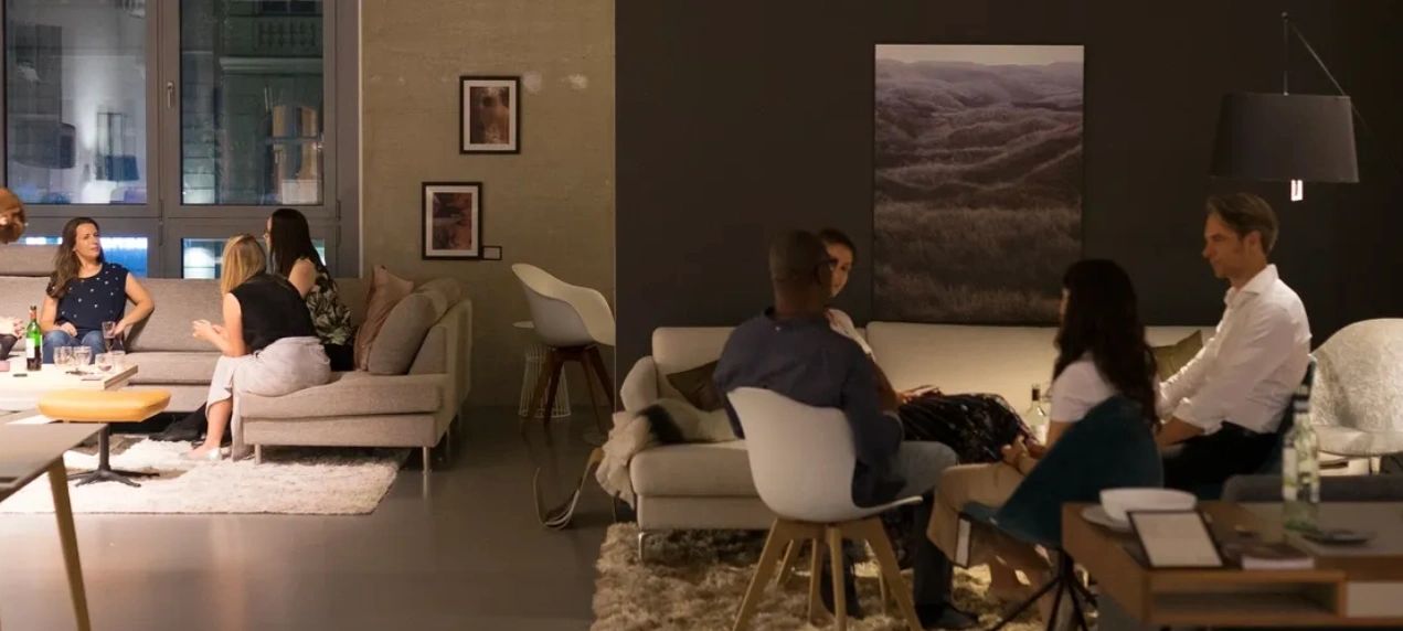 People socializing in a cozy, modern living room with comfortable seating.
