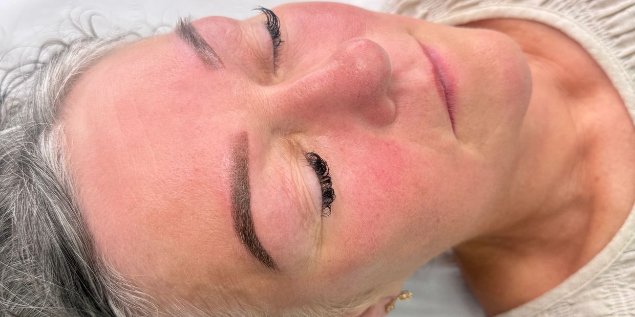 Close-up of a woman's face with closed eyes and well-groomed eyebrows.