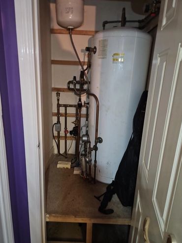 White water heater in a small utility closet.