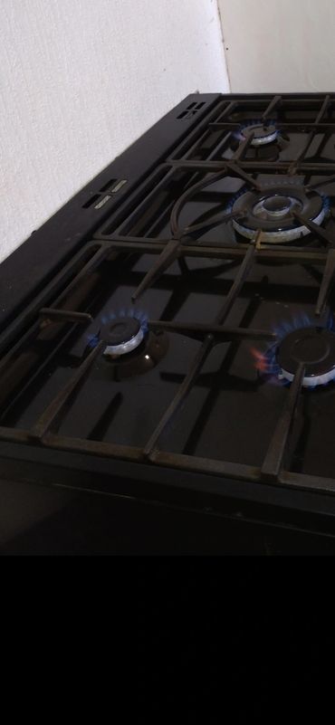 Gas stovetop with multiple burners lit.
