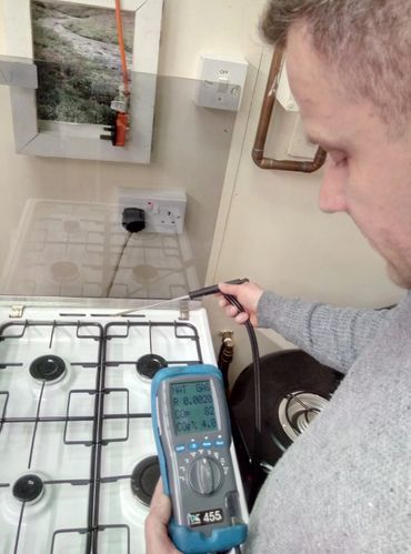 Person using a gas analyzer on a stove.