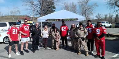 Group of people posing outdoors next to a white tent.