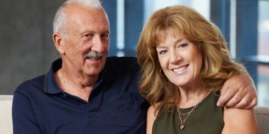 Smiling couple sitting closely together indoors.