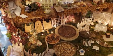 Miniature garden scene with tiny furniture and fairy lights.