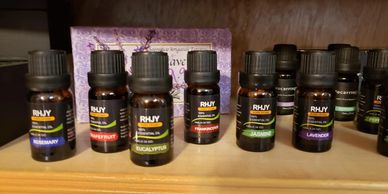 Bottles of RHY essential oils including rosemary, peppermint, and eucalyptus on a wooden shelf.