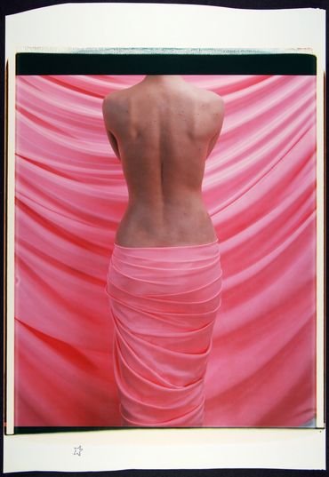 A pink fabric wrapped around a topless woman 