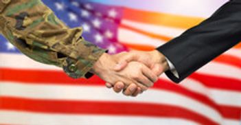 Military and civilian handshake with American flag background.