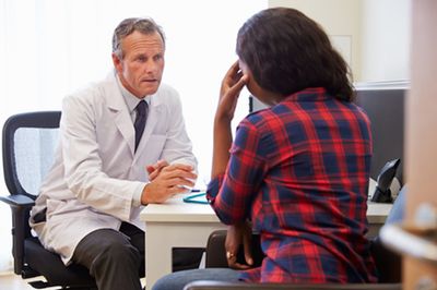 A woman talking to a male doctor
