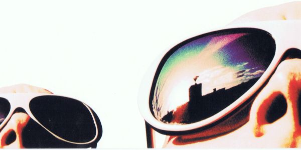 Close-up of mirrored sunglasses reflecting a city skyline.