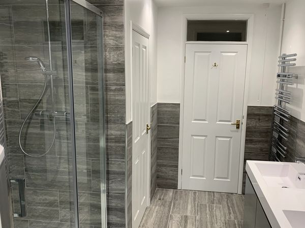 Floor tiles, wall tiles, shower cubicle and designer radiator