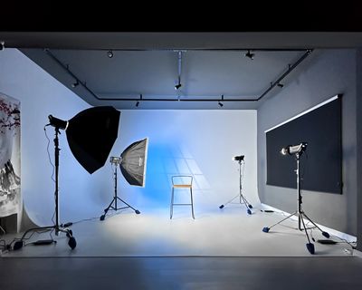 um estúdio de fotografia com fundo infinito e equipamentos de iluminação