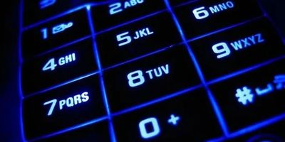 Close-up of a glowing blue numeric keypad with letters.