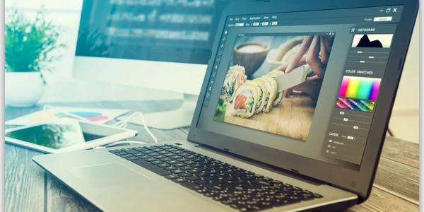 Laptop displaying photo editing software with sushi image.