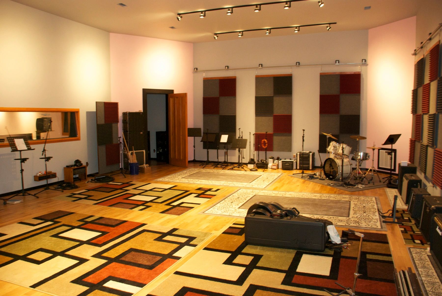 Spacious music studio with instruments and soundproofing panels.