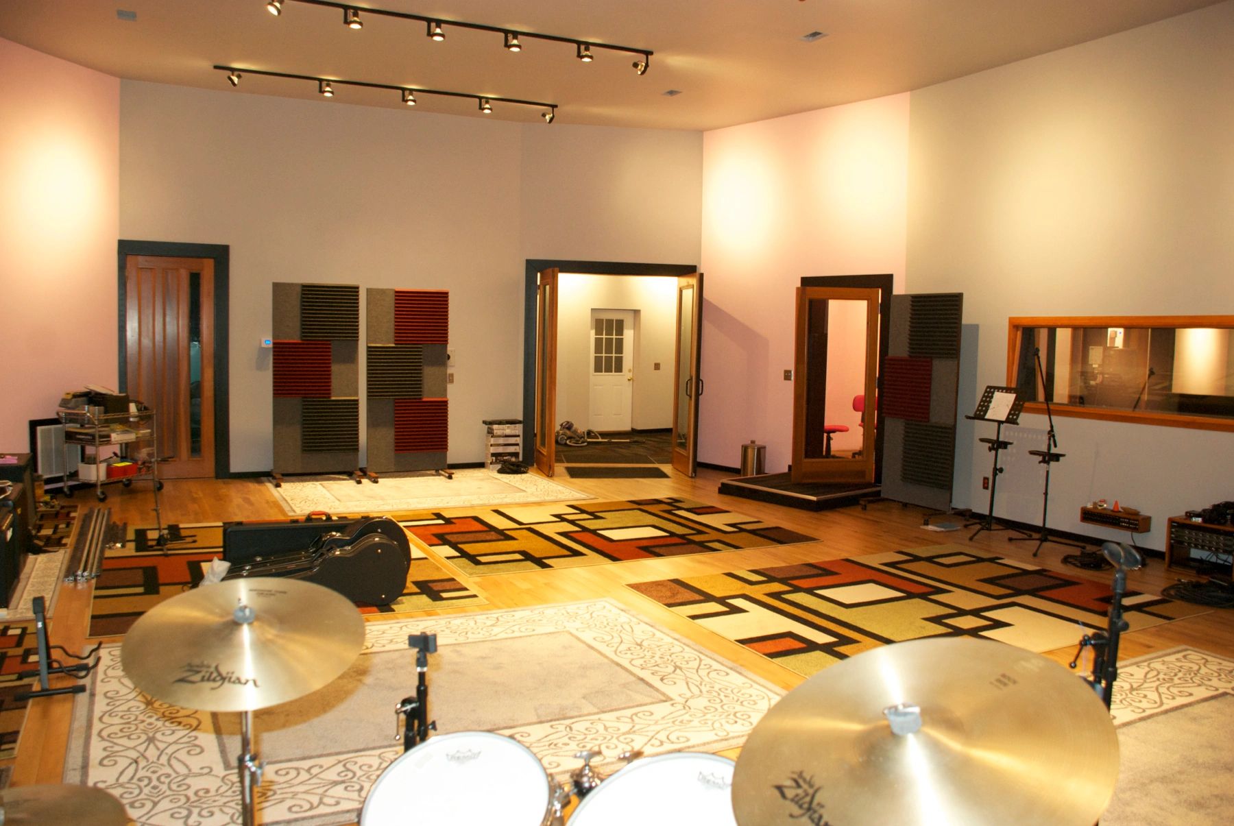 Spacious music rehearsal room with drum set and acoustic panels.