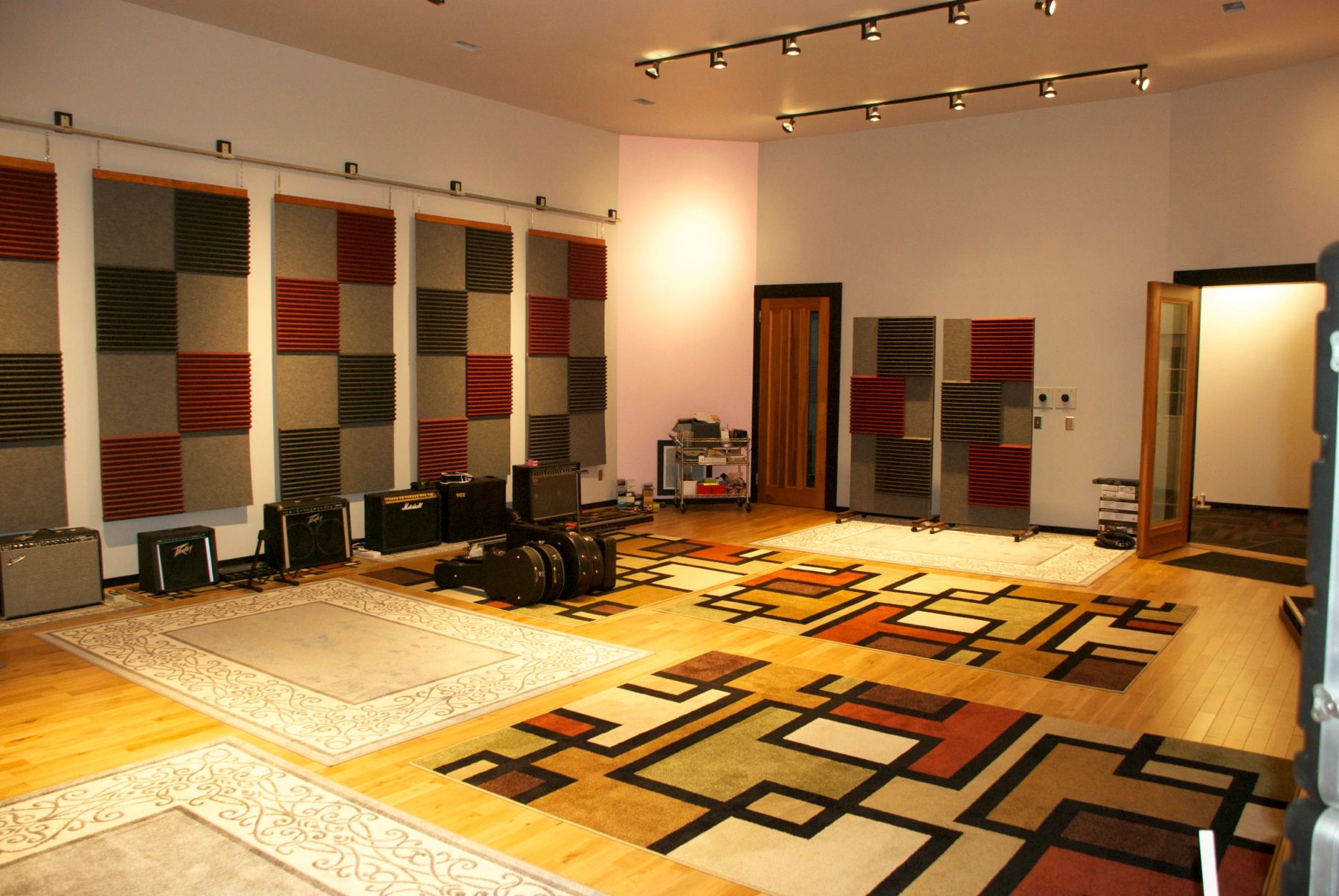 Large music studio with acoustic panels and guitar amps.
