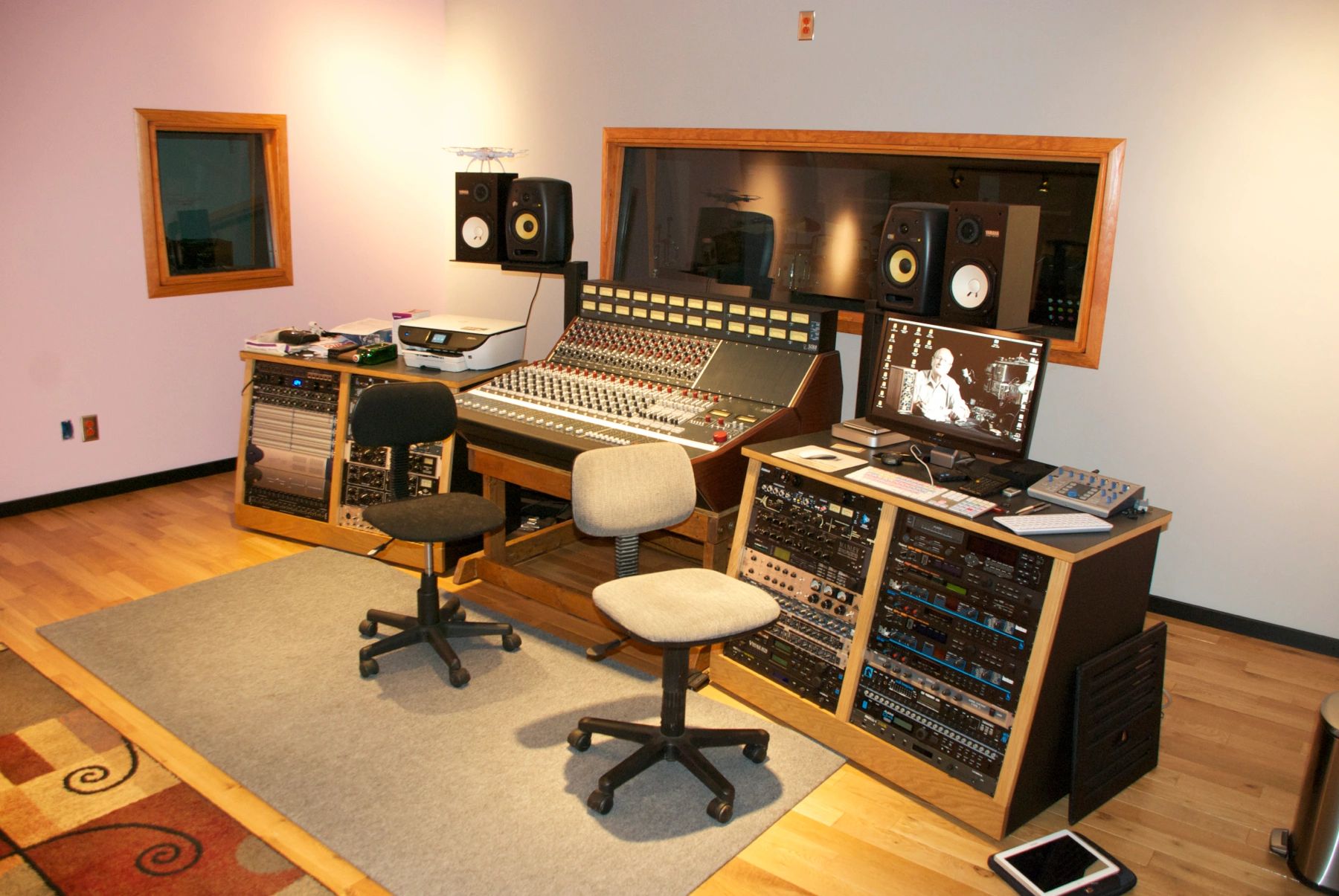 Audio recording studio with mixing console and chairs.