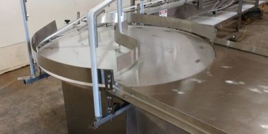 Feed turntable to load bottles onto the filler conveyor then into the liquid filling machine.