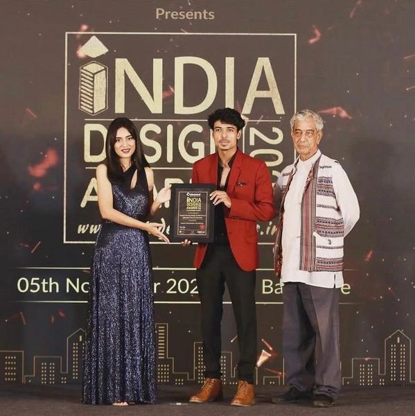 Three individuals at India Design Awards 2023, with one receiving a plaque.