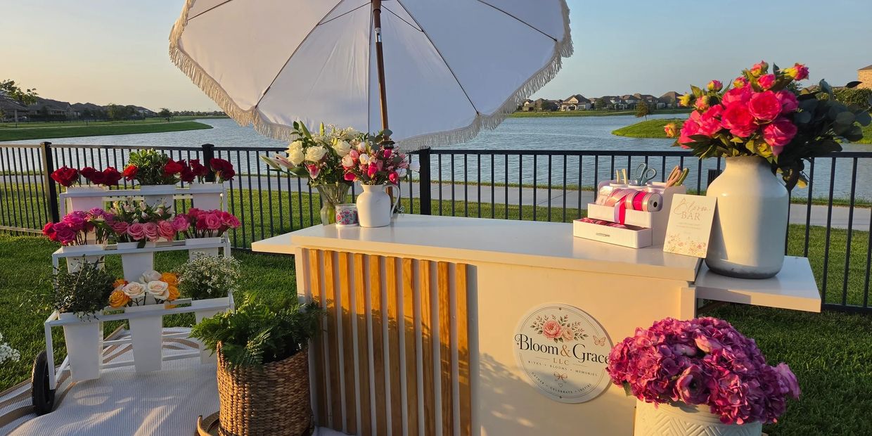 Flower stand with umbrella by the lake.