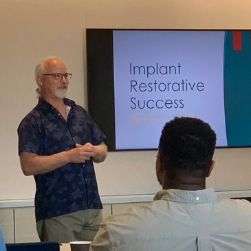 A man presenting on the screen the implant restorative success