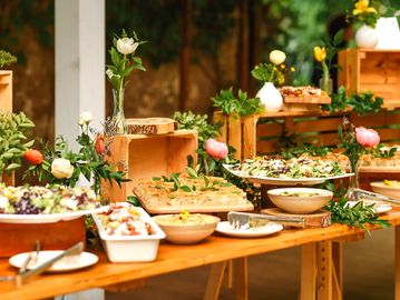 Elegant buffet table with fresh salads and floral decorations.