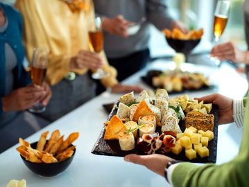 People enjoying finger foods and drinks at a social gathering.