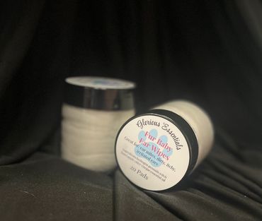 Jars of Glorious Essentials Fur Baby Ear Wipes on a black cloth.