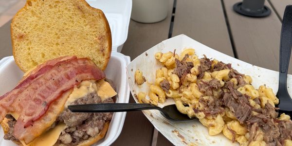 Burger with bacon and mac and cheese with beef outdoors.