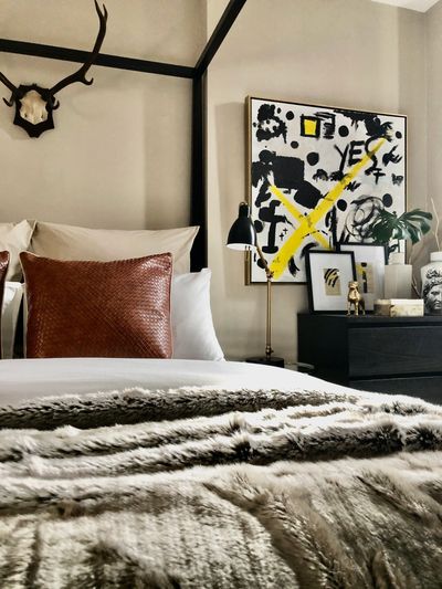 a living room with a yellow and black painting.