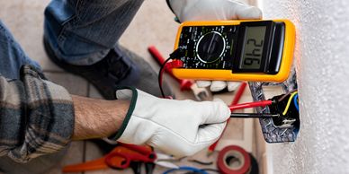 Professional checking wiring with a multimeter—electrical service, troubleshooting, and repairs.