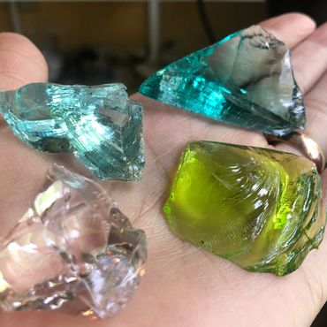 Close-up of colorful glass shards held in a hand.