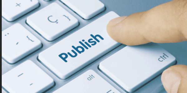 Close-up of a finger pressing a keyboard key labeled 'Publish'.