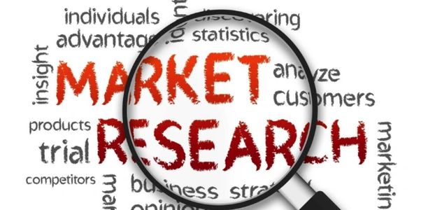 Magnifying glass highlighting the words Market Research and related terms.