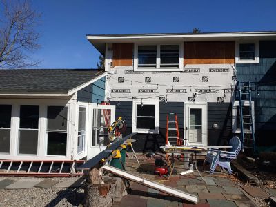 Siding renovation in progress in Oswego, NY, by Rexyco LLC, showing house wrap and blue siding.