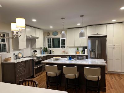 Two-tone kitchen remodel by Rexyco LLC, with white and wood cabinets and marble counters.