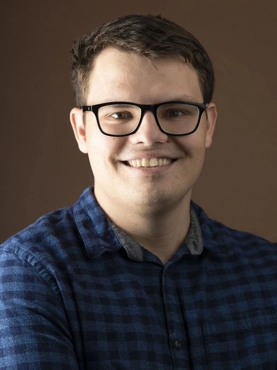 Man in glasses smiles at the camera
