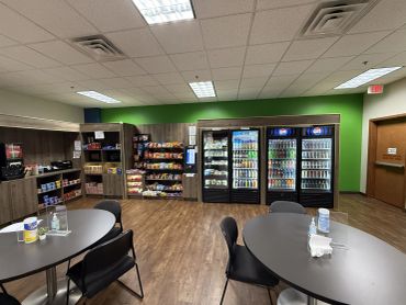Complete employee break room featuring refrigerated beverages, fresh food coolers, snack options, an