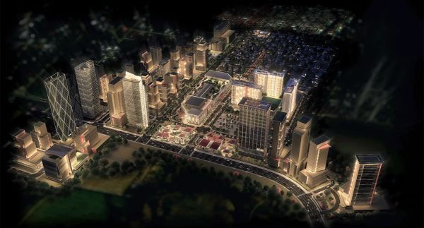 Aerial night view of a cityscape with illuminated buildings.