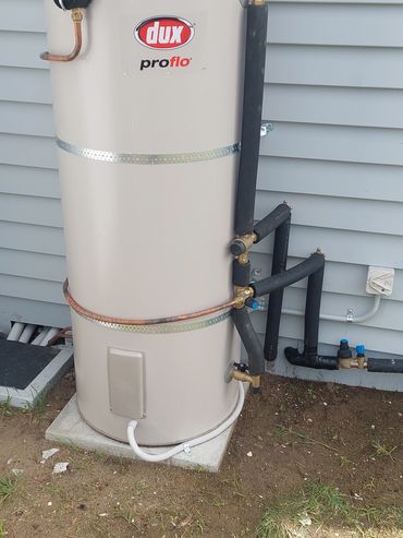 Outdoor Dux proflo water heater installed beside a house.