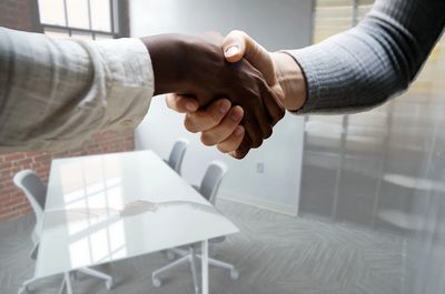 two people shaking hands in a conference room