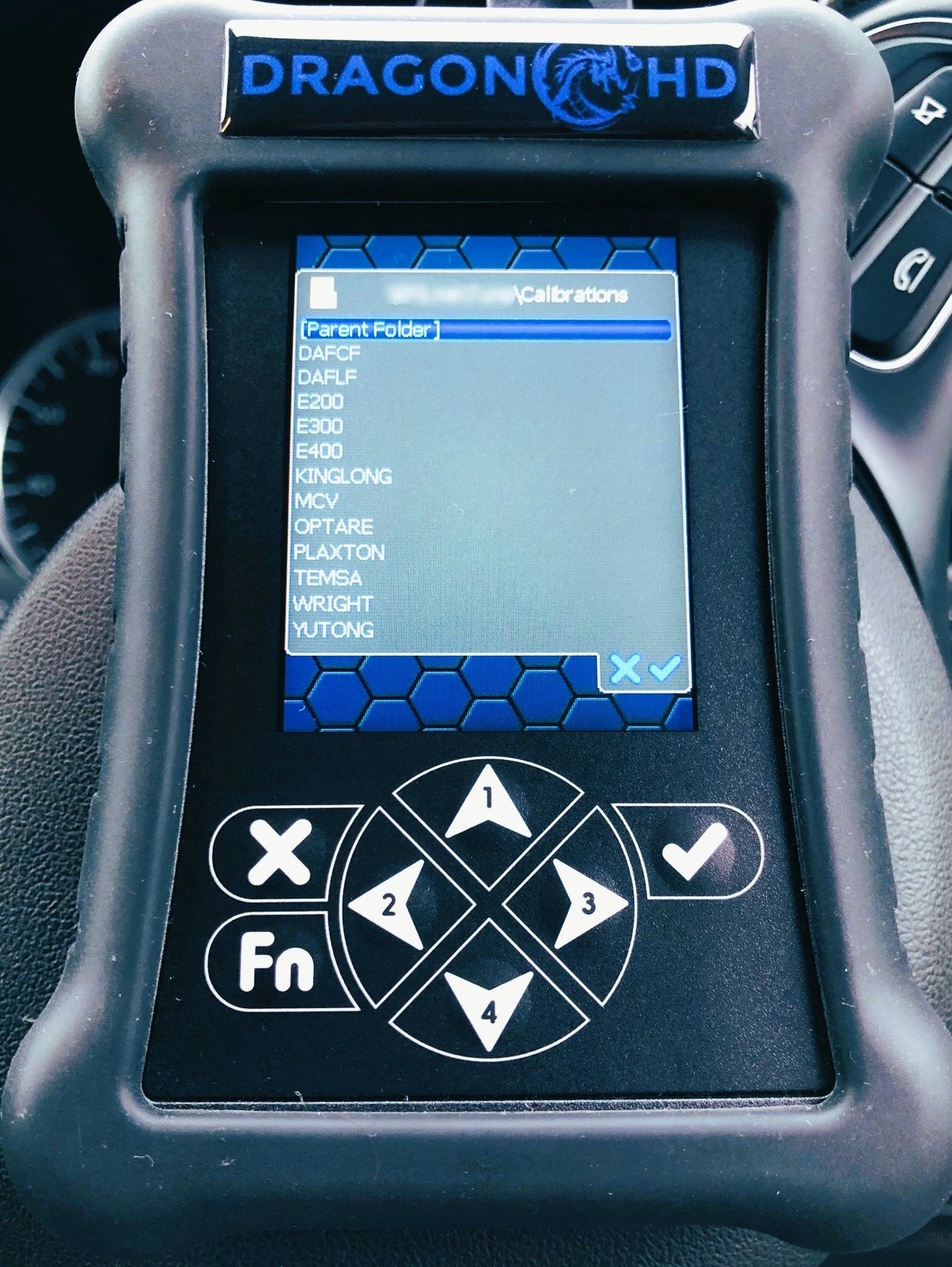 Handheld Dragon HD diagnostic tool displaying calibration options.