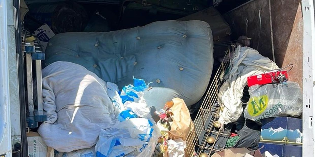 van filled with old cushions, bags, and miscellaneous items.