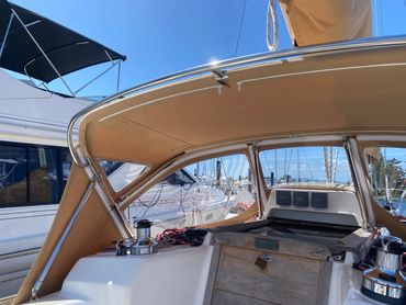 Interior view of a sailboat cockpit with tan canvas cover on a sunny day.