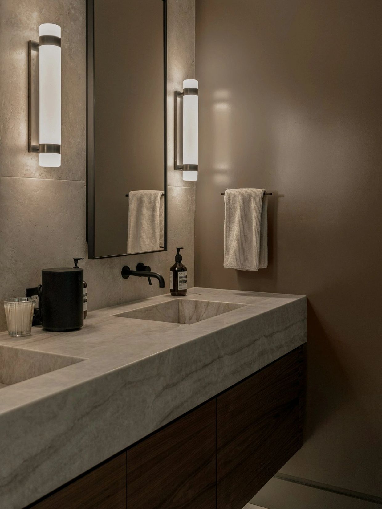 Modern bathroom with marble countertop and muted lighting.