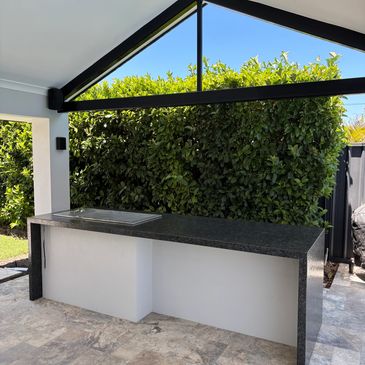 Outdoor kitchen counter with greenery background.