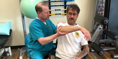 Physical therapist manually stretching patient's shoulder