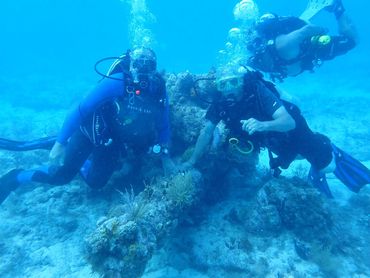 Students from finding sunken treasure class next to under water cannon