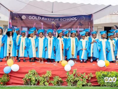 Children in blue graduation gowns at Gold Avenue School ceremony.